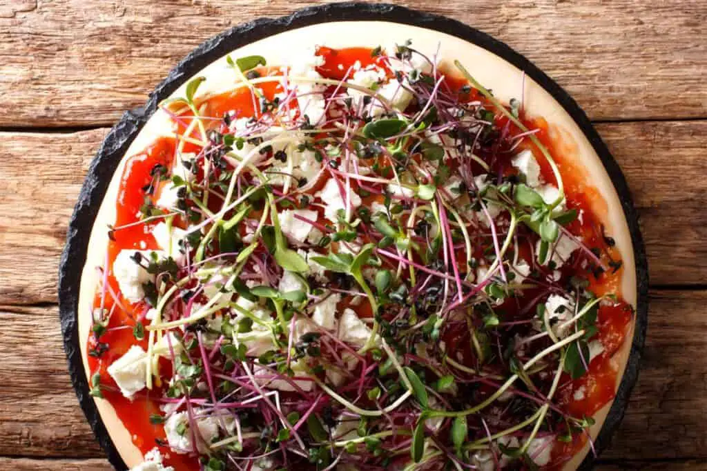 Microgreens on a pizza with tomato and feta cheeze