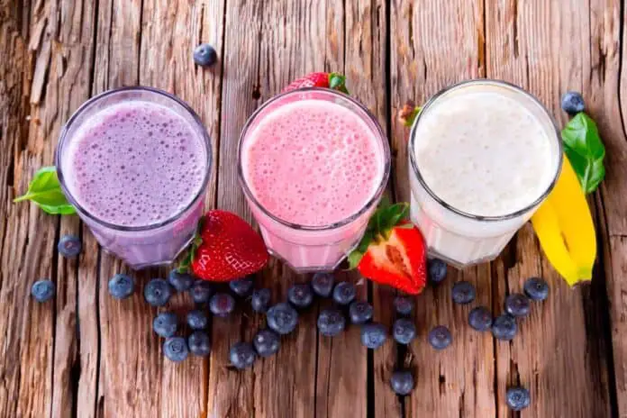 3 different microgreen smoothies on a wooden table